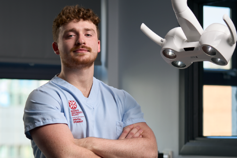 QUB dental student standing beside dentistry equipment